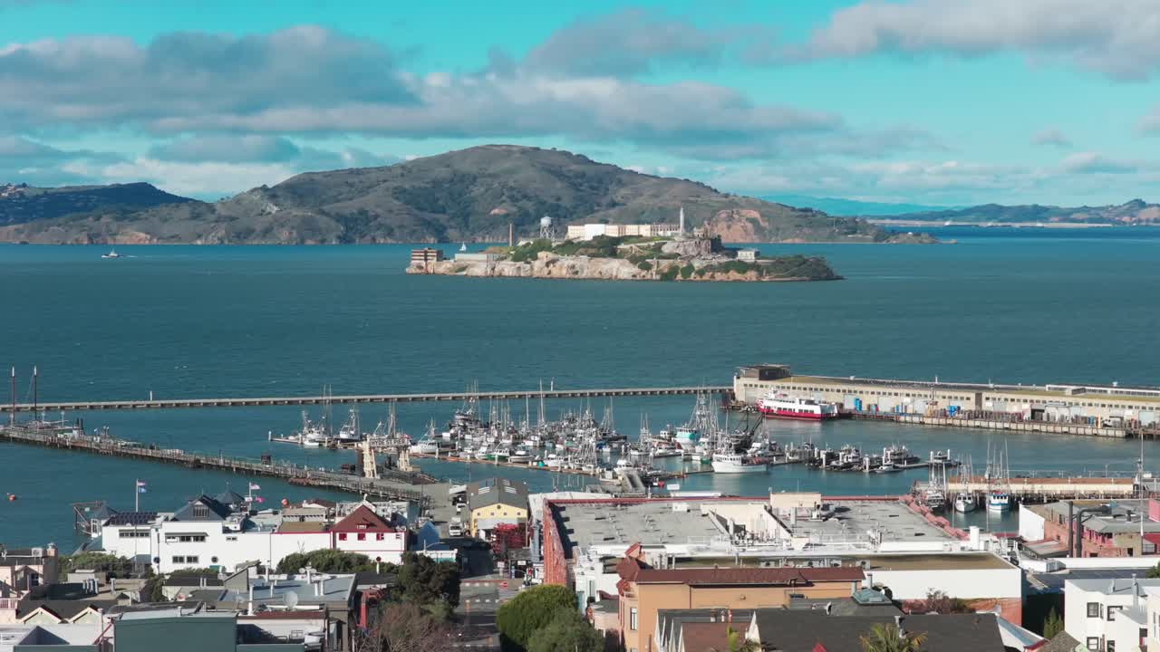 Wide panning aerial shot the San Francisco National Maritime Historical Park at Fisherman's Wharf with Alcatraz Island in the distance in Northern California. 4K