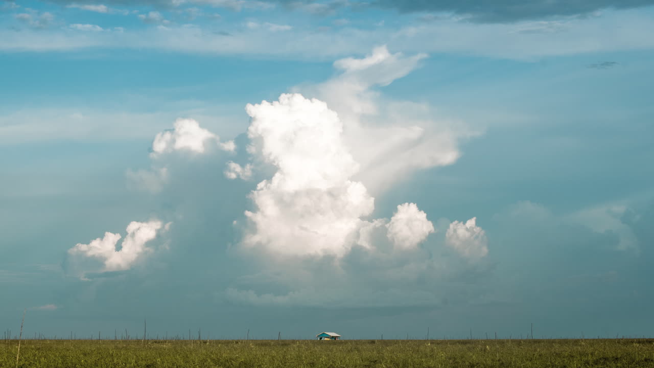 동남아시아 몬순 시즌 동안 위에 폭풍우 구름이 형성된 깨끗한 지평선에 있는 단순한 집