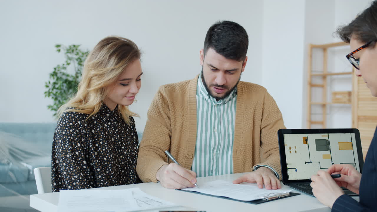 Couple Signing House Purchase Documents