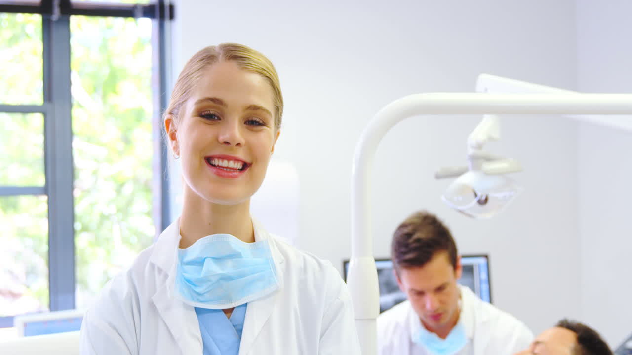 Portrait of smiling dentist standing with arms crossed