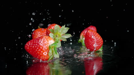 strawberries fall onto a wet surface, splashing droplets of water in slow motion and macro