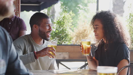 young couple meeting in sports bar enjoying drink before game