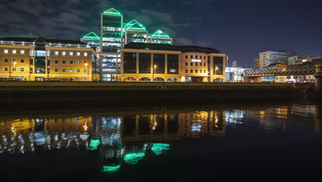 Lapso-De-Tiempo-Del-Edificio-Del-Banco-Ulster-Iluminado-Por-La-Noche-Con-Tráfico-A-Lo-Largo-Del-Río-Liffey-En-La-Ciudad-De-Dublín-En-Irlanda