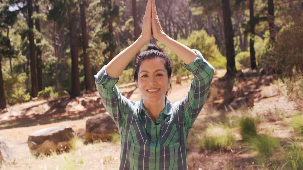 la mujer está haciendo yoga en el bosque.