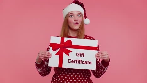 Funny-girl-wears-red-New-Year-sweater-and-hat-presenting-card-gift-certificate-coupon-winner-voucher