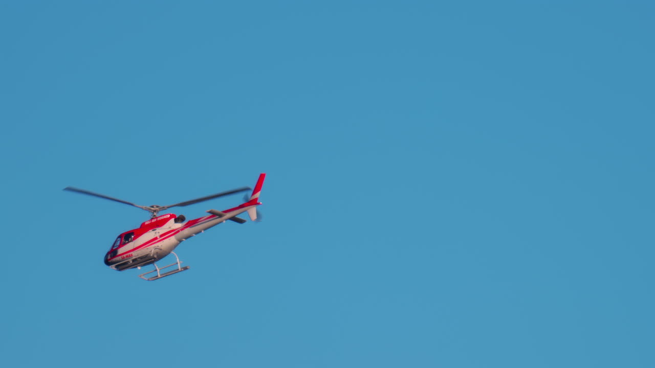 赤と白の色を持つヘリコプターが空を飛ぶ | Premium写真