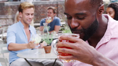 young couple meeting for drinks at outdoor tables in restaurant making a toast