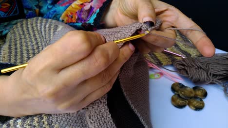 close-up-shot-of-professional-woman-hands-crocheting-woolen-sweater-in-slow-movement