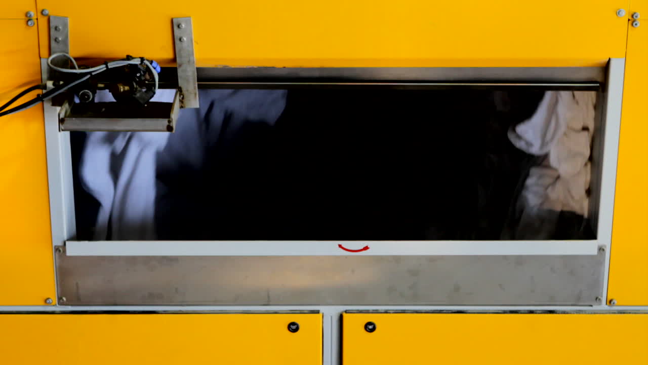 la ropa se tira en una gran secadora, girando en un fondo negro