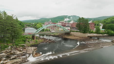 aerial view of androscoggin river, green bridge, and rumford maine paper mill with steaming stacks