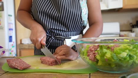 slicing salami to add to a romaine lettuce chopped salad - antipasto salad series