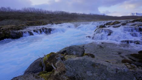 Atemberaubende-Aufnahme-Von-Schwimmendem-Wasser-Am-Wasserfallrand,-Umgeben-Von-Felsen-In-Der-Natur