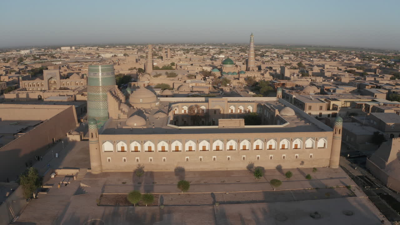 우즈베키스탄의 옛 성벽으로 둘러싸인 히바 시에 있는 이찬 칼라와 알라 쿠리 칸 마드라사의 공중 드론 포인트