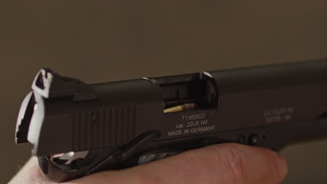 primer plano de una pistola abierta con una bala lista para ser alojada