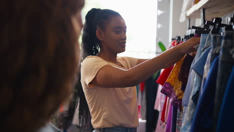 two friends shopping for clothes in fashion store together