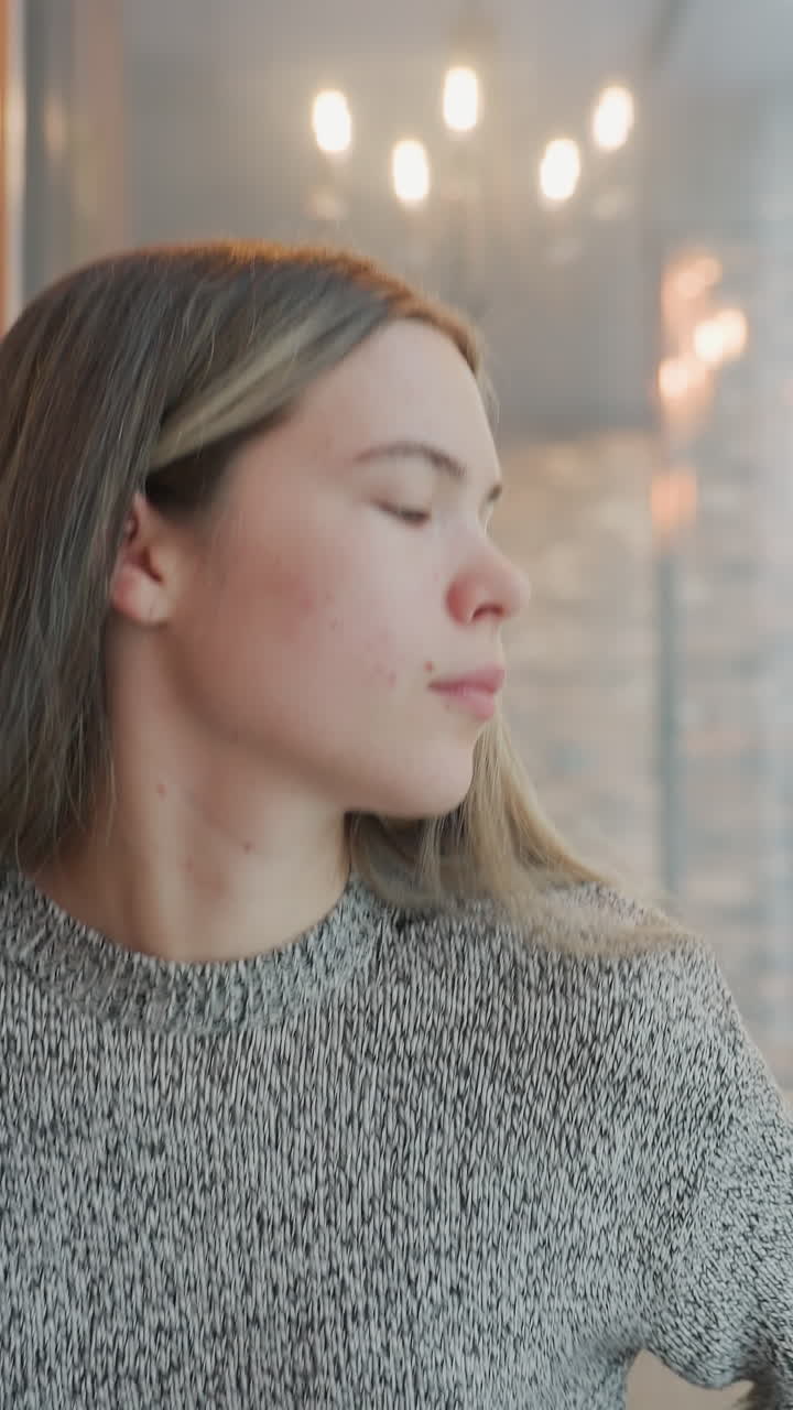Calm urban retreat, Serene woman relaxes peacefully, Peaceful city scene with woman enjoying quiet moment, Serene woman peacefully relaxing while observing tranquil cityscape through window