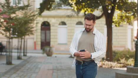 young man tourist worry about being late looking around check time in smartphone app lost in city