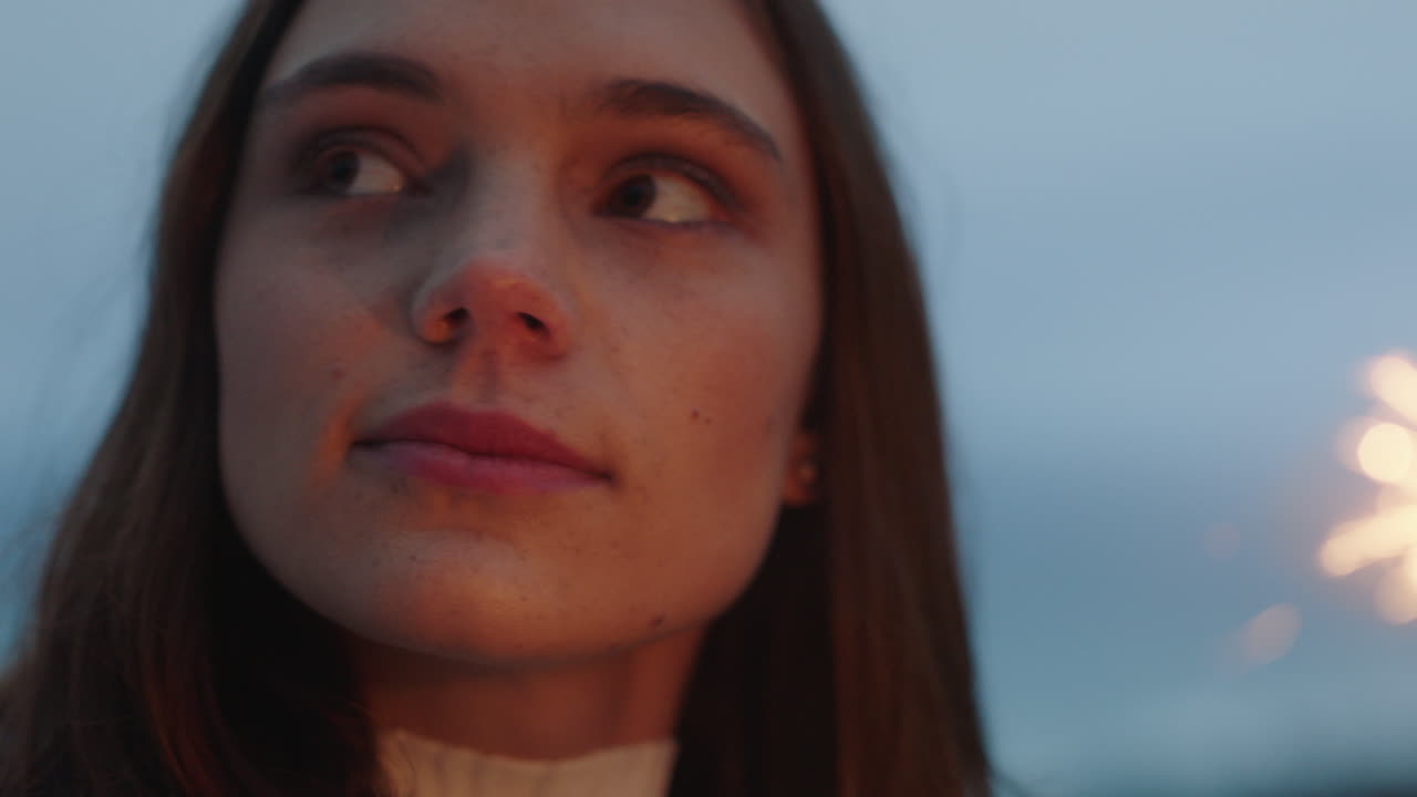 cerrar bengalas mujer feliz celebrando el día de la independencia disfrutando de la celebración de año nuevo divirtiéndose con fuegos artificiales festivos en la playa al atardecer