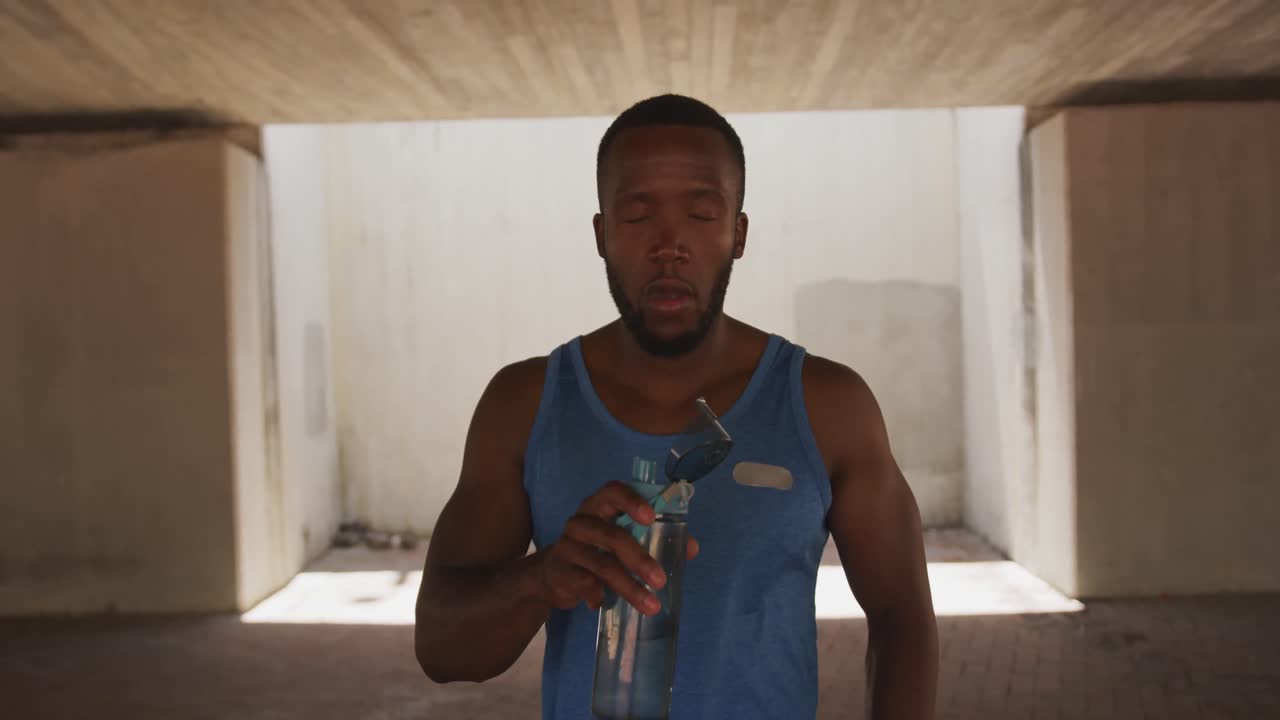 Man training in an urban setting taking a break