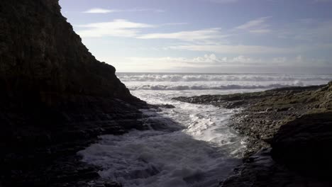 Olas-Rompiendo-En-Formaciones-Rocosas-En-La-Playa