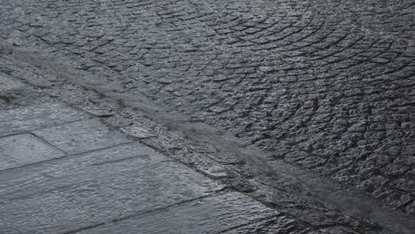 rain pours down along the old town with cobblestone streets in bergen, norway. close-up shot
