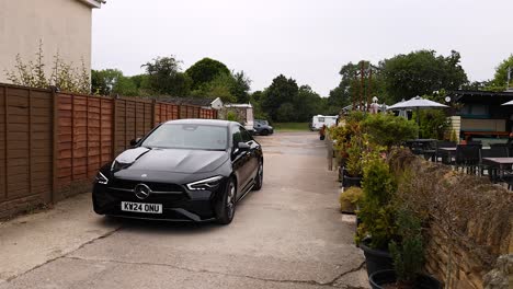 black car navigating a narrow alleyway in oxford