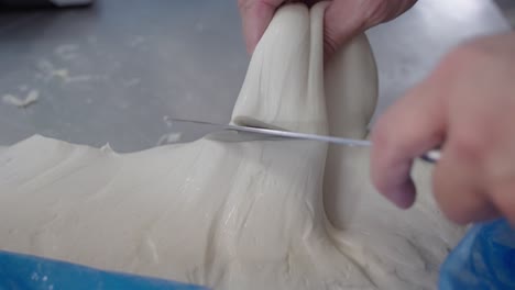 cortando un trozo de masa de pizza.