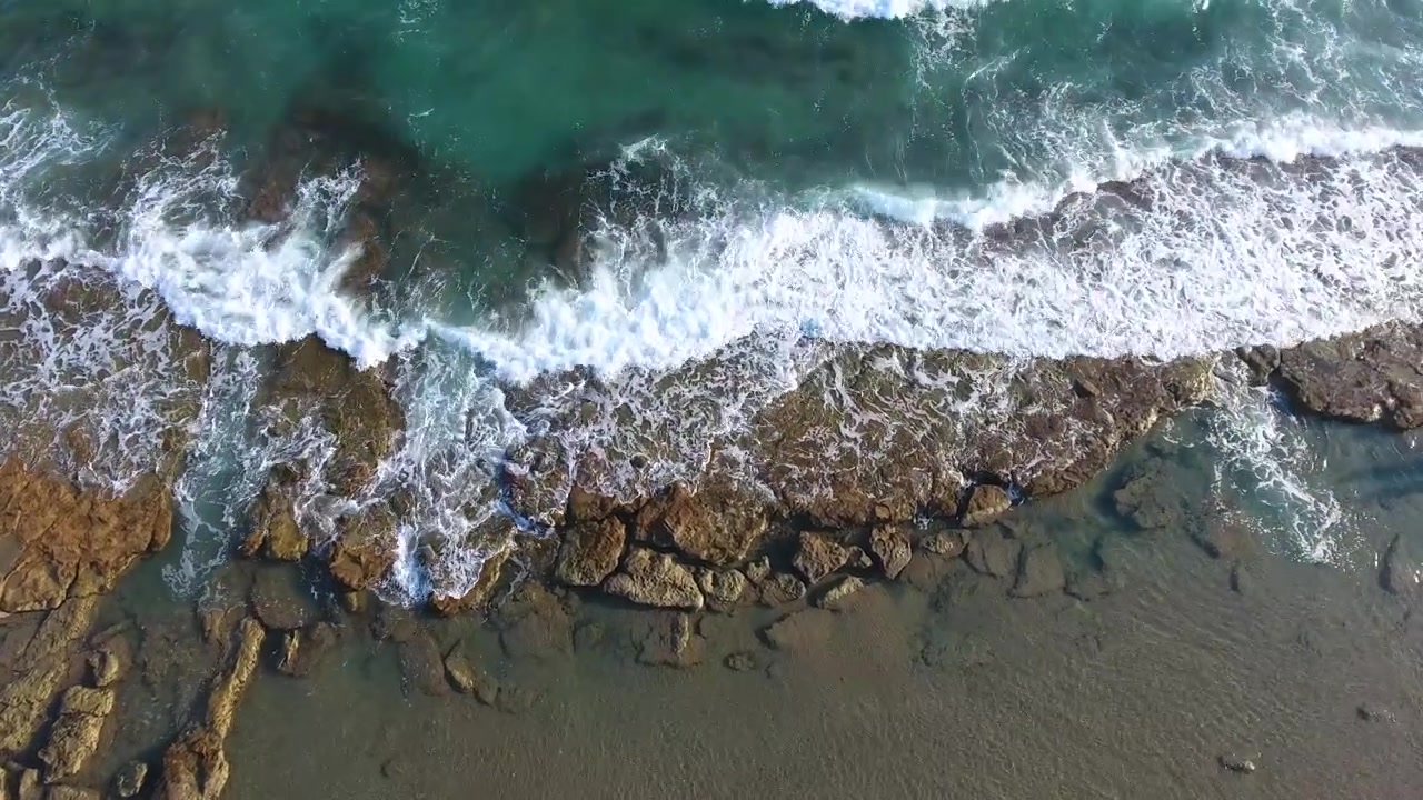 Vista aerea delle onde dell'oceano che si schiantano contro la costa rocciosa