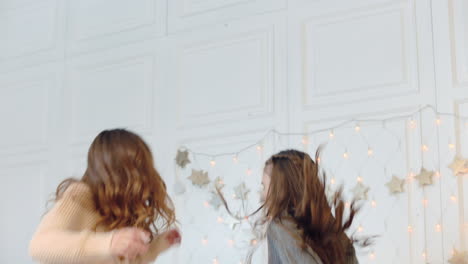 smiling mother and daughter making dance party on bed in luxury house.