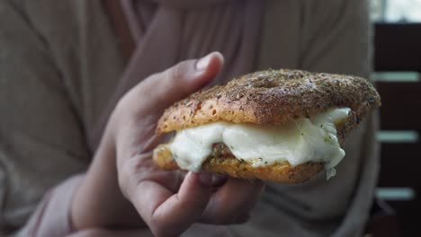 persona con un sándwich de queso