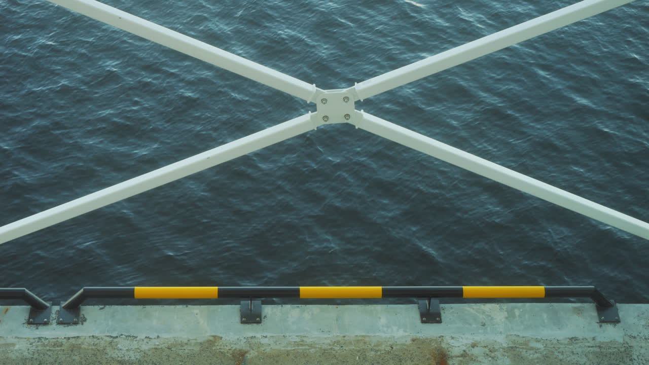 Static view of a quay bordered by white bars as a cross