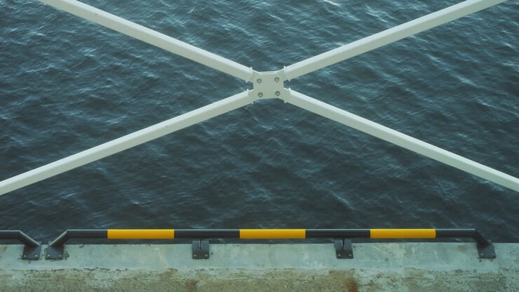 Static view of a quay bordered by white bars as a cross