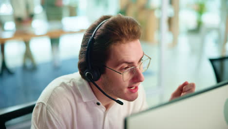 hombre con auriculares trabajando en un escritorio en una oficina
