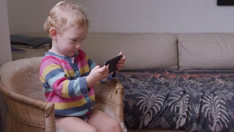 Baby-playing-on-smartphone-in-living-room-at-home