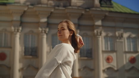 woman enjoying the outdoors in front of a historical building
