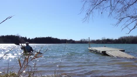 a kayaker launches from the dock onto the lake