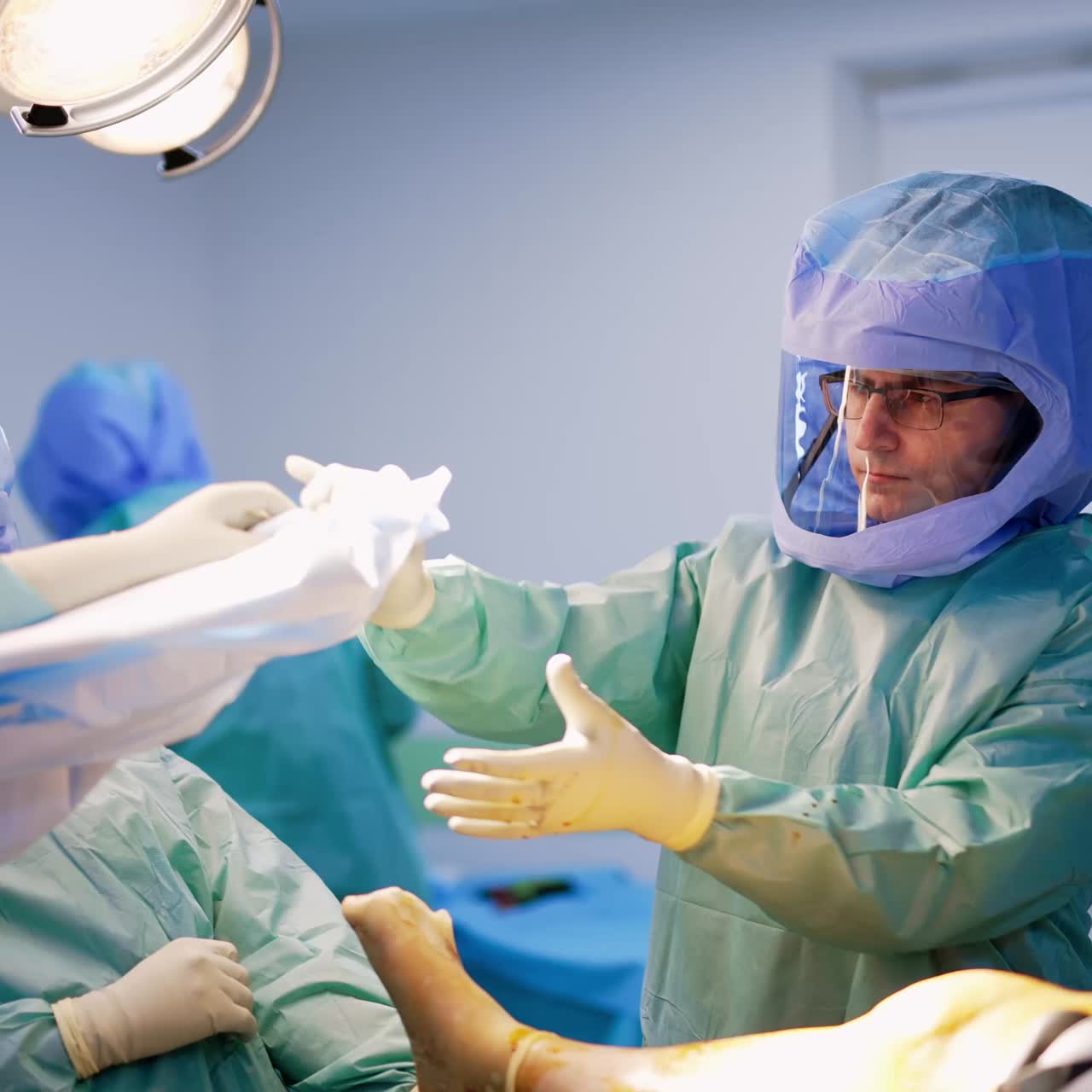 Preparation for trauma surgery on a leg. Doctors cover patient's leg with a special cloth