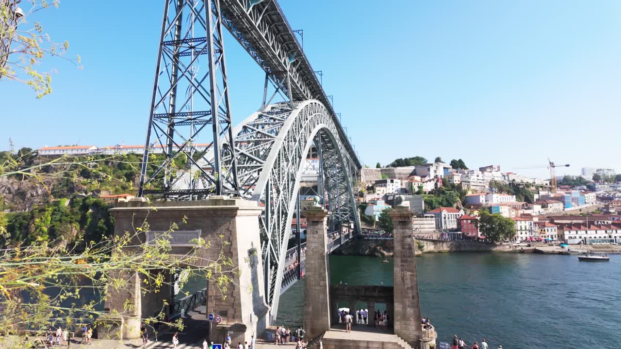 The view over Porto's Douro River with boats, rooftops, and the Luis I Bridge under a bright sky