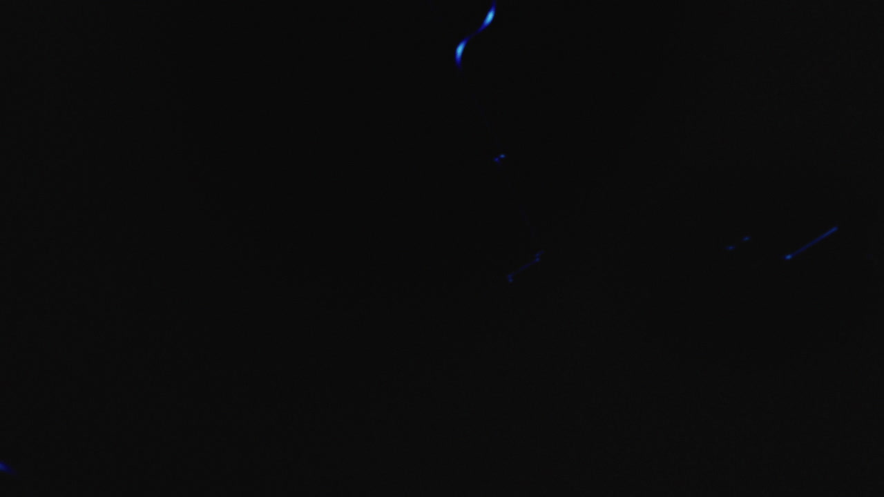 Pistols on the dark background and in blinking red and blue lights are falling in slowmotion