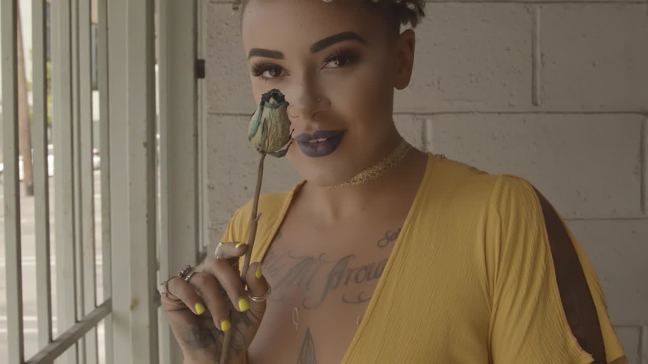 Slowed video sequence of a woman with rose in yellow dress