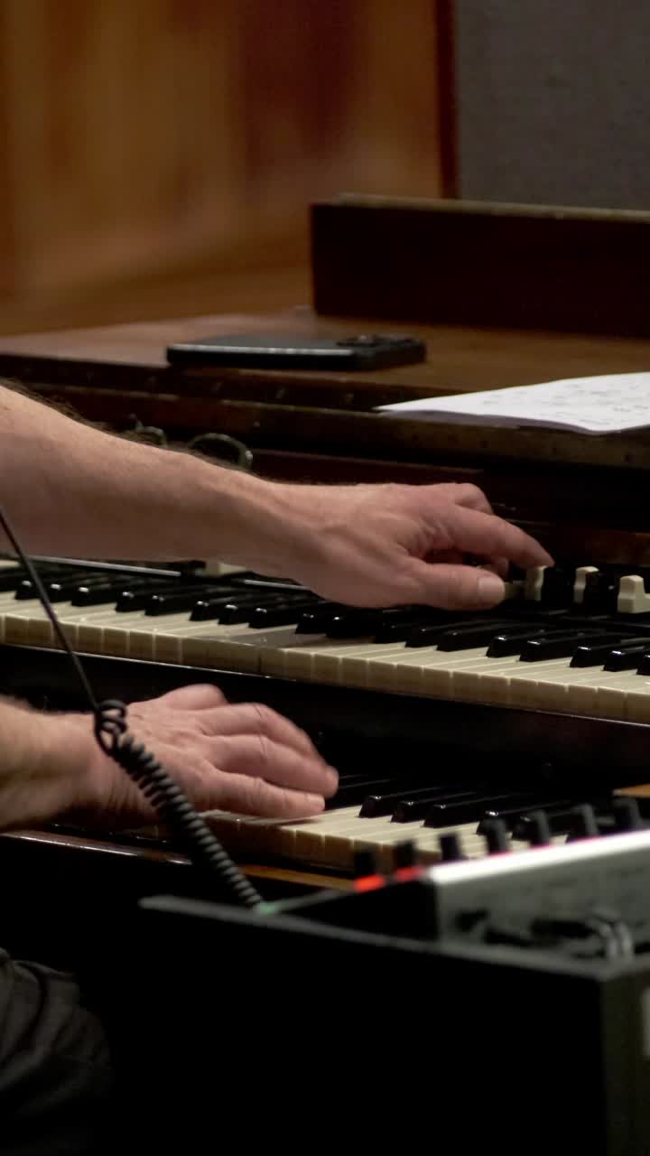 Musician Playing Hammond B3 Electric Organ, Adjusting Drawbars With One Hand While Playing Keys. vertical shot