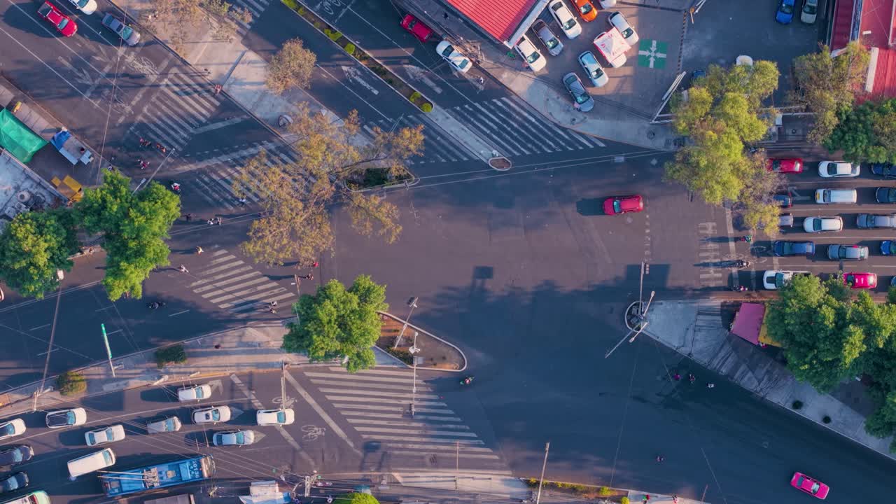 Top-down drone shot of a busy urban intersection with pedestrians