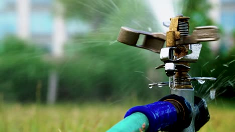 pulsating sprinkler, tight shot, sprinkler moves slowly to the right and fast to the left