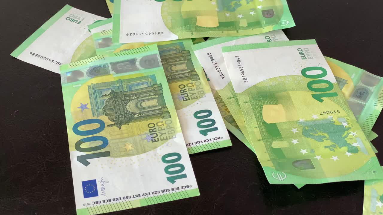 Den største pengeseddel i Europa, grøn 100-euroseddel, falder på bordet.
