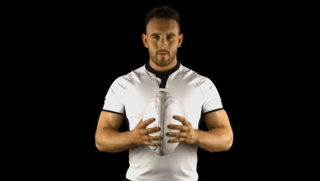 jugador de rugby serio sostiene la pelota de rugby