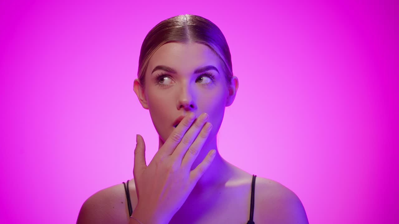 la mujer se cubre la boca con la mano en estado de shock, expresión facial de incredulidad