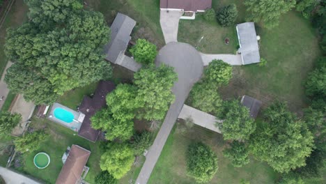 an aerial view of village playing fields, residential houses and green tree in a small town