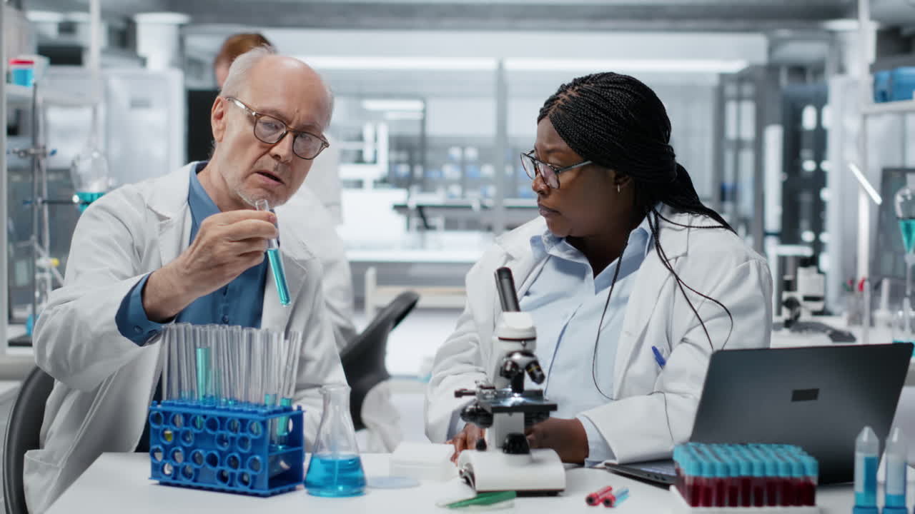 Chimistes analystes de laboratoire travaillant ensemble, étudiant un polymère liquide