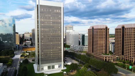 buildings by riverfront and downtown in richmond, virginia | aerial view circling up | summer 2021