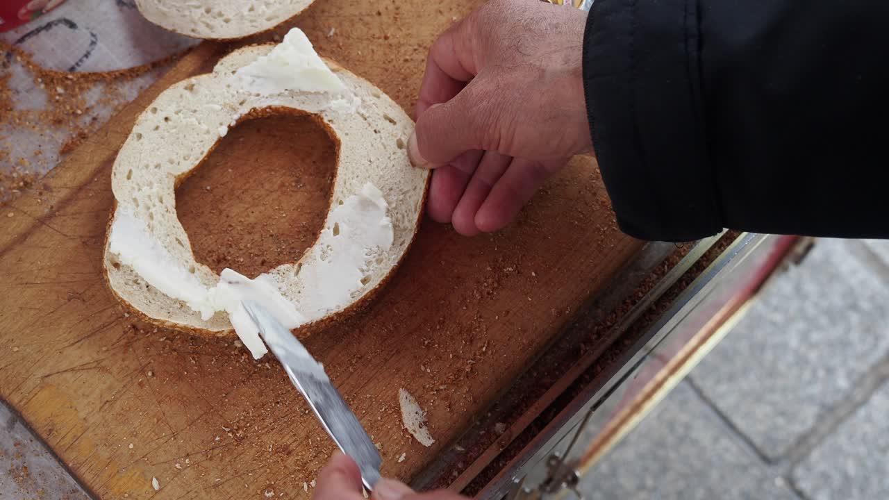 베이글 에 크림 치즈 를 뿌리는 남자 의 클로즈업